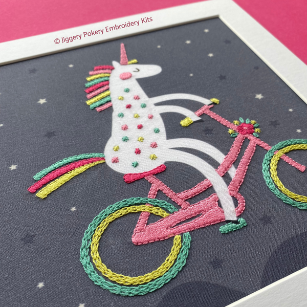 Unicorn hand embroidery pattern in white mount on pink background