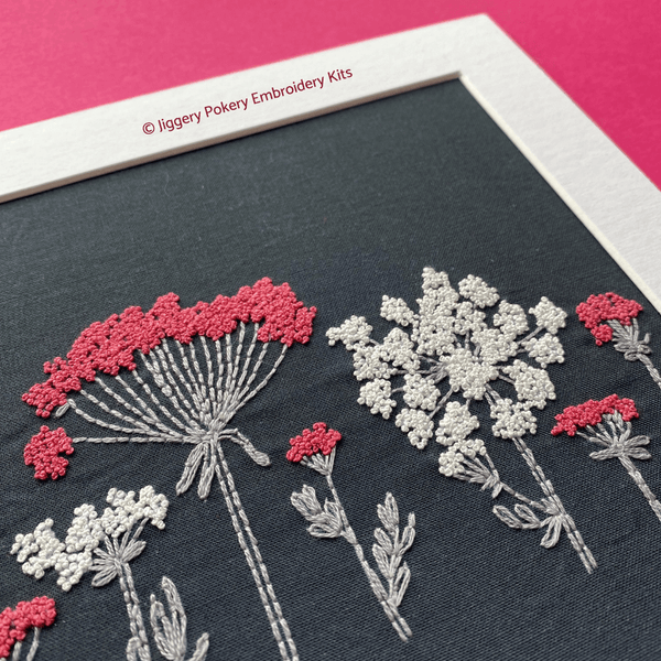 Wildflower embroidery design close-up in mount showing pink and white French knot blossoms