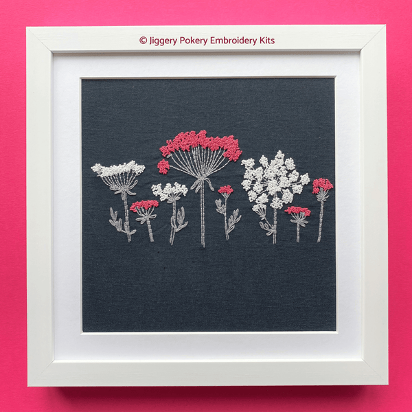 Wildflower embroidery pattern in square white frame shown on a pink background